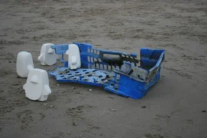 PHiNG-THiNGs bekijken een plastic krat aangespoeld op het strand